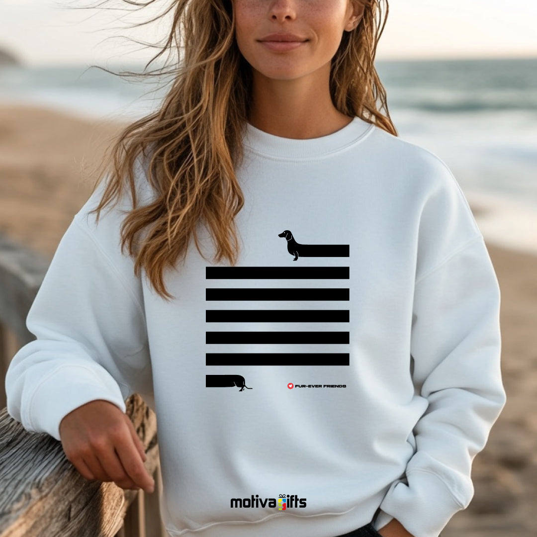 A woman wearing a White Dachshund Long on Charm White Sweatshirt featuring a illustration of a dachshund with an extra-long body and quirky charm