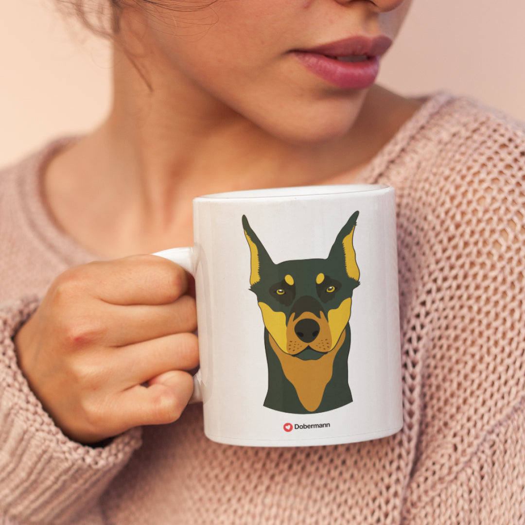 A woman holding a white 11oz ceramic mug featuring Dobermann Dog art printed on both sides