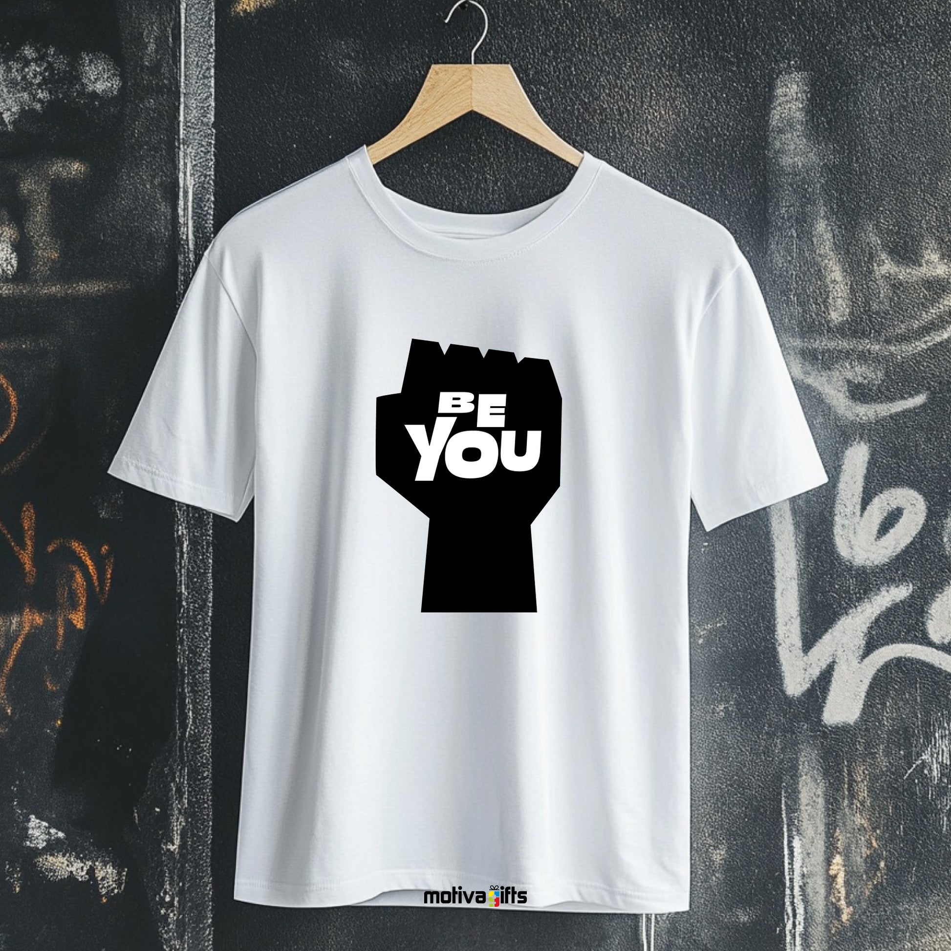 A hanging white T-shirt featuring bold black typography that reads Be You 