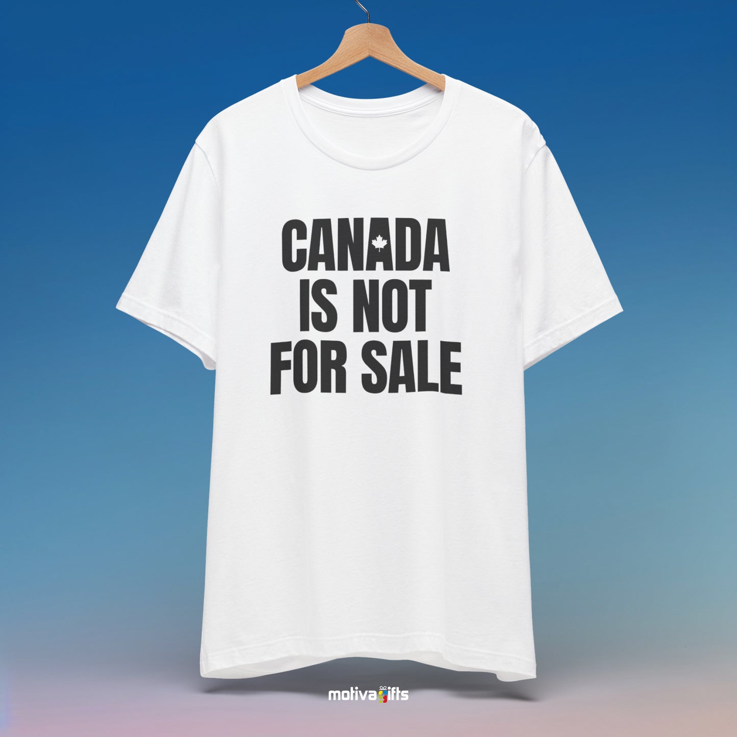 A hanging white T-shirt featuring bold black typography that reads Canada is Not for Sale