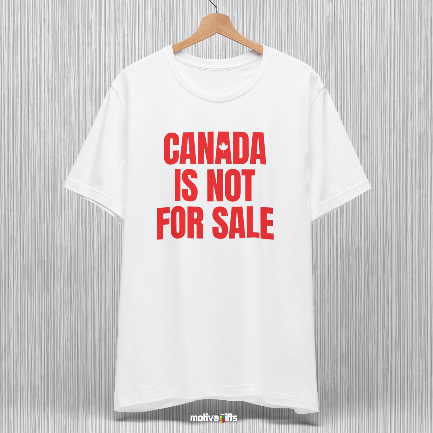 A hanging white T-shirt featuring bold red typography that reads Canada is Not for Sale