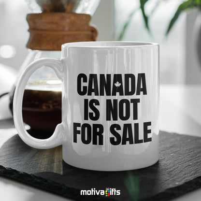 Canada is Not For Sale reads in black bold letters on a white 11 oz ceramic mug, featuring a black table.