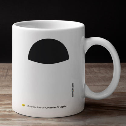 White ceramic mug with a drawing of Charlie Chaplin's mustache featuring a rustic table