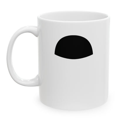 Photo of a white ceramic mug with a drawing of Charlie Chaplin's mustache, set against a plain white background.