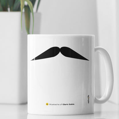 White ceramic mug with a drawing of Clark Gable’s mustache featuring a rustic table. 