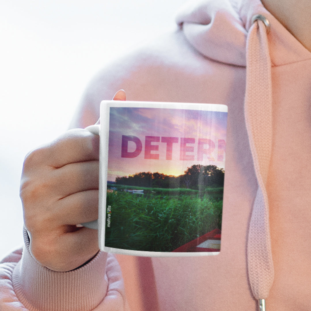 Woman holding a white ceramic mug with a wraparound design displaying the word ‘Determination’ above a quote by Confucius: ‘Wherever you go, go with all your heart’