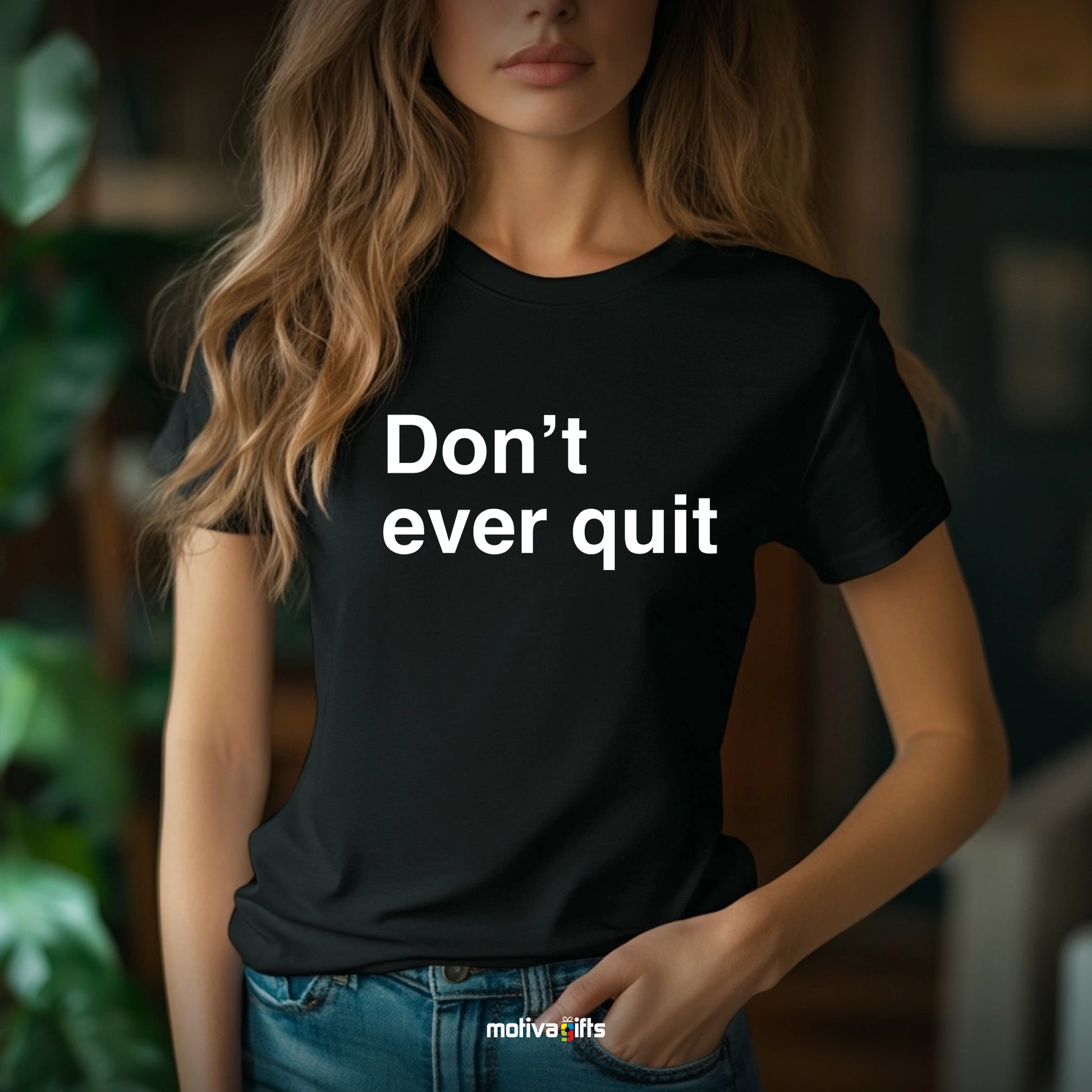 A woman wearing a black T-shirt featuring bold white typography that reads Don’t ever quit