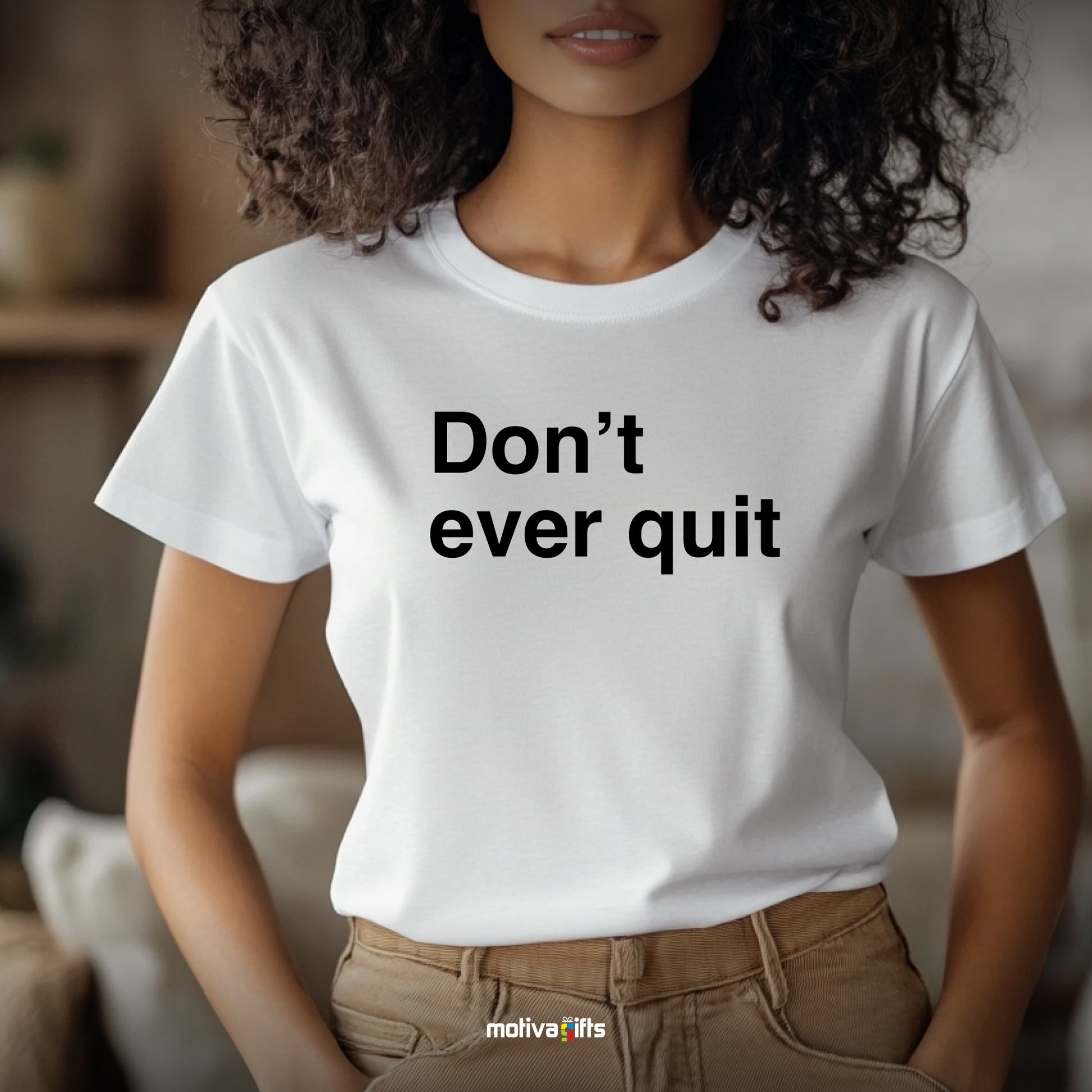 A woman wearing a white T-shirt featuring bold black typography that reads Don’t ever quit