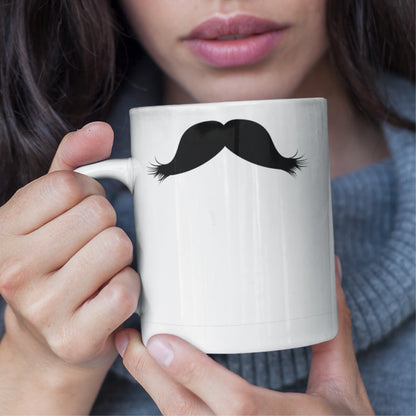 Woman holding a white ceramic mug with a drawing of Friedrich Nietzsche’s mustache, set against a plain white background.