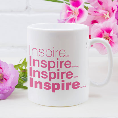 Right View Inspire White Mug placed over a white table surrounded by pink flowers
