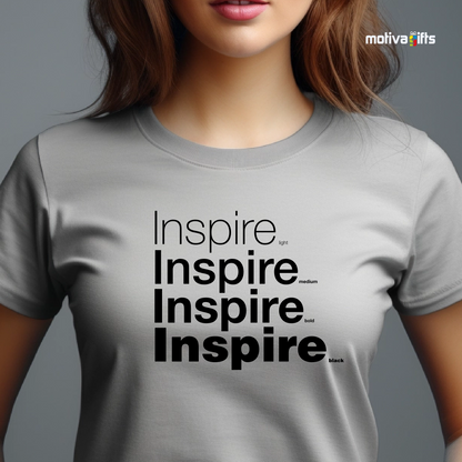 Woman using Sport Gray unisex t-shirt with Inspire printed in black on the front in four lines with different font weights (light, medium, bold, black). Made of cotton and polyester, short sleeves, crewneck. By Motiva Gifts.