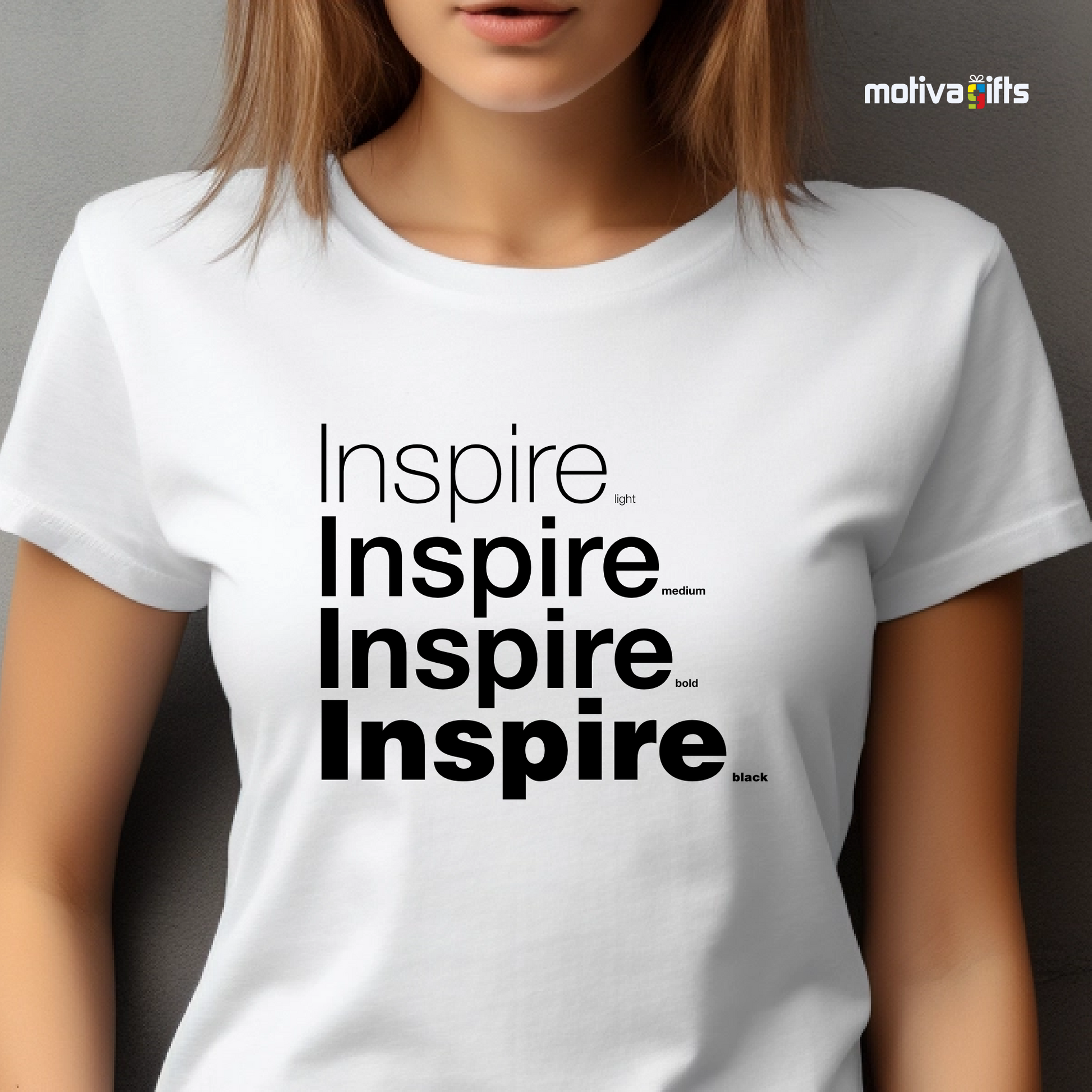 Woman using White unisex t-shirt with Inspire printed in black on the front in four lines with different font weights (light, medium, bold, black). Made of cotton and polyester, short sleeves, crewneck. By Motiva Gifts.