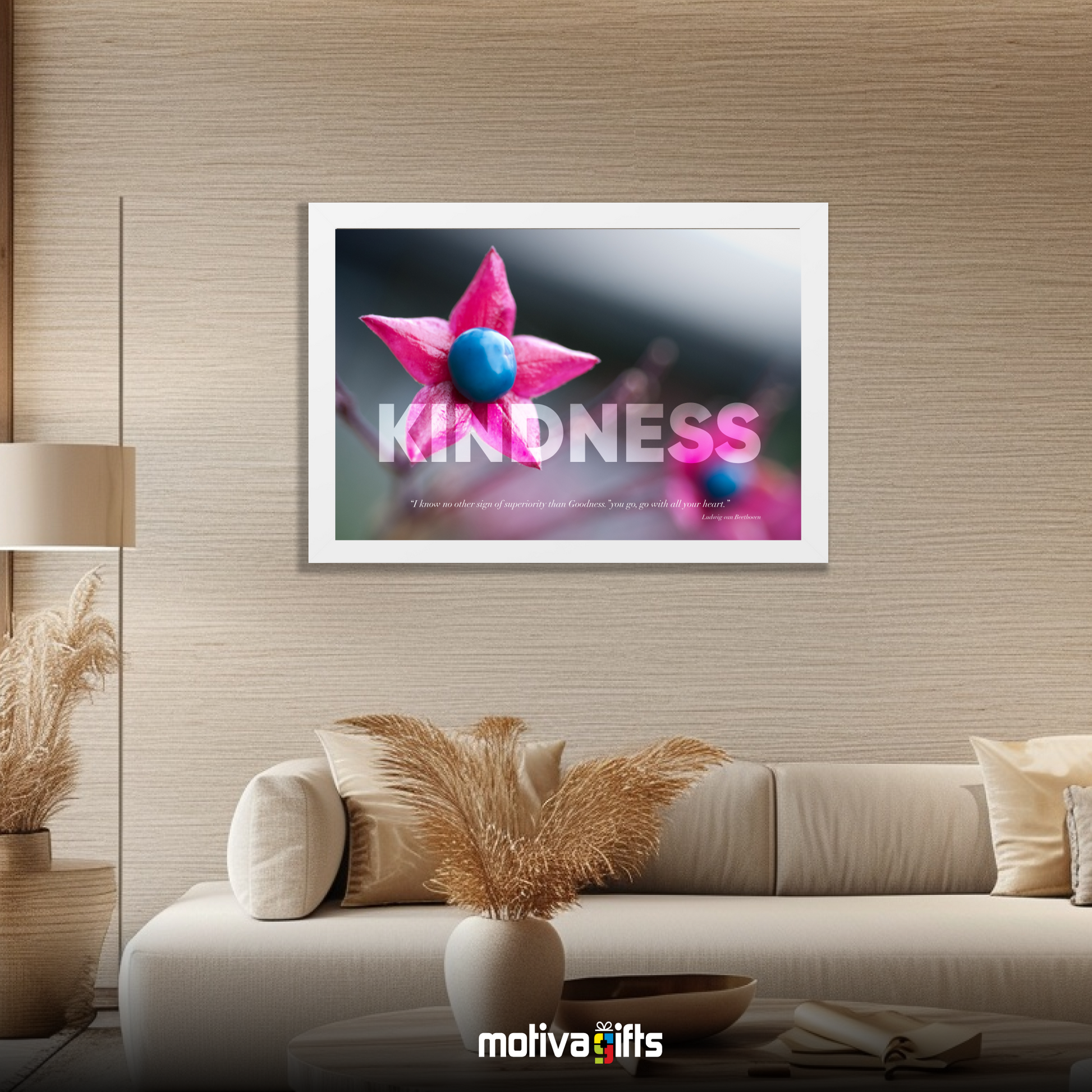 A white framed art wall with the word KINDNESS in large text and Beethoven quote hangs in a modern living room