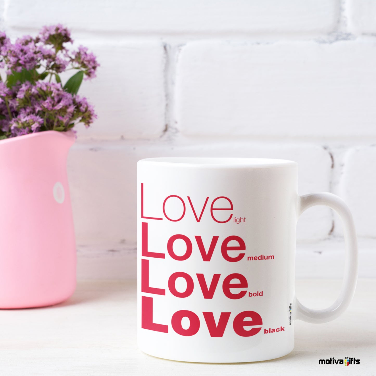 Love Motivate Words White Mug next to a pink ornament