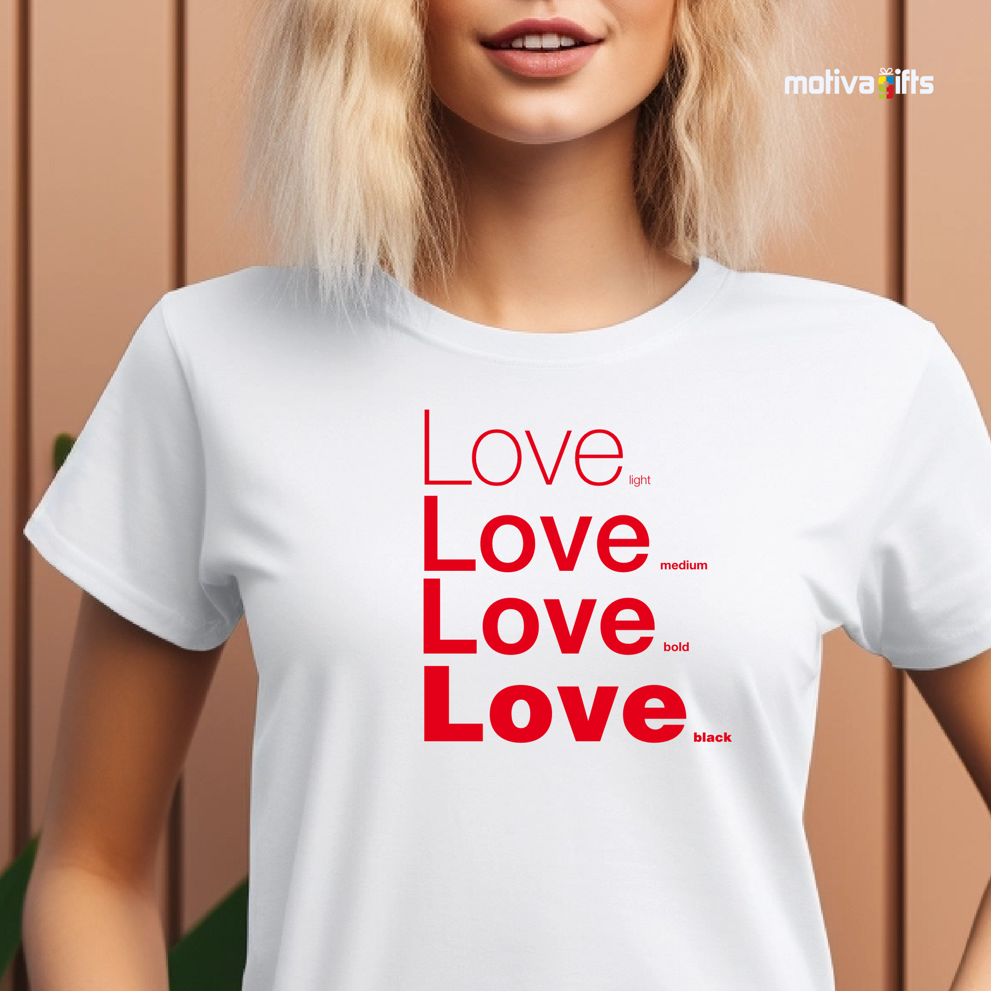 Woman using White unisex t-shirt with Love printed in red on the front in four lines with different font weights (light, medium, bold, black). Made of cotton and polyester, short sleeves, crew neck. By Motiva Gifts.