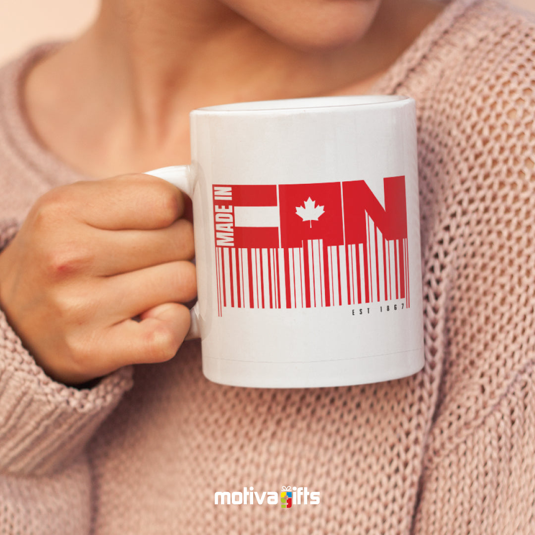 A woman holding a white 11oz ceramic mug that reads in red bold Made in CAN art printed on both sides