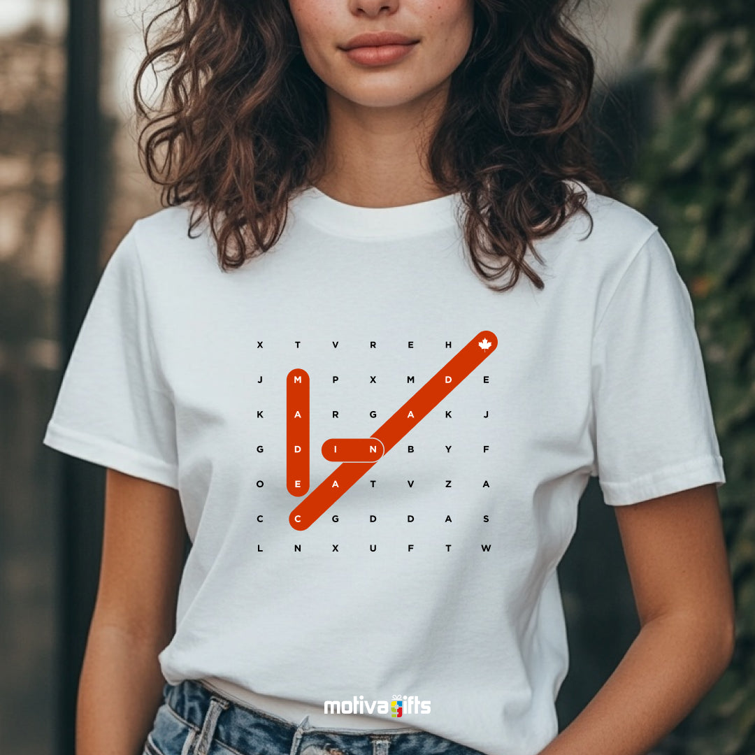 A woman wearing a white T-shirt featuring bold white and red typography that reads Made in Canada Crossword