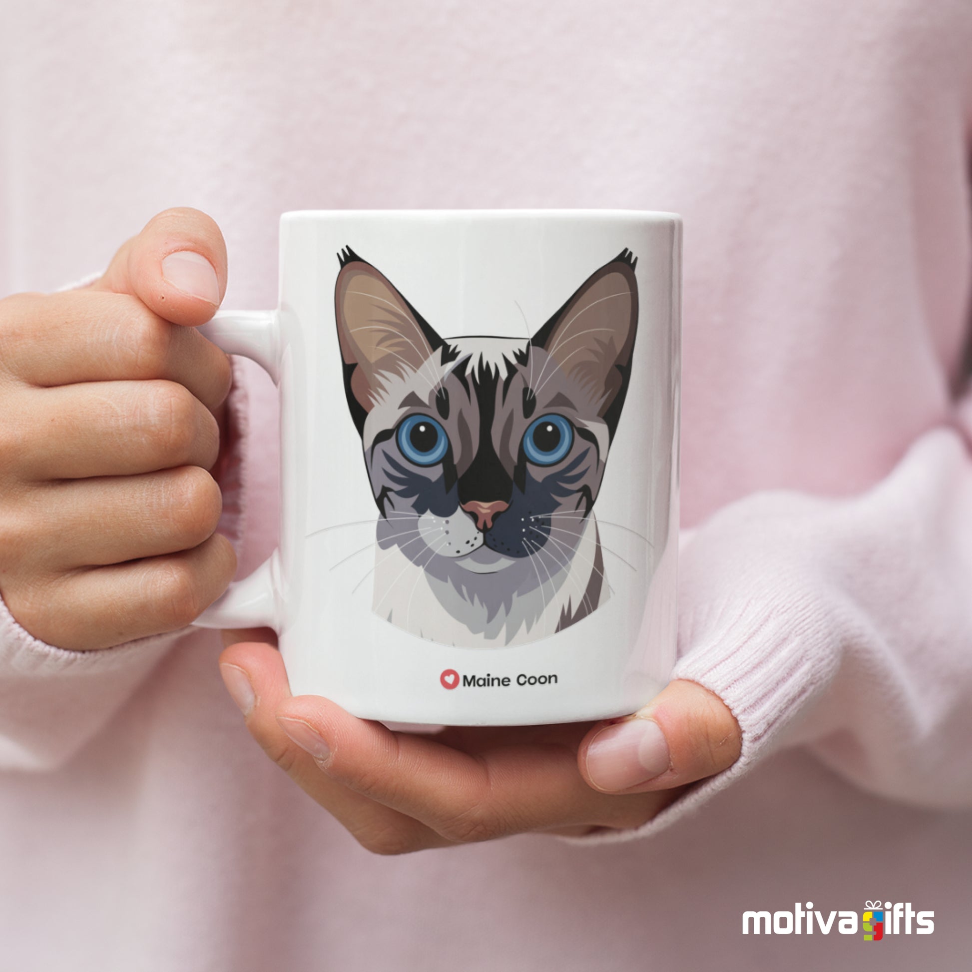 A woman holding a white 11oz ceramic mug featuring Maine Coon cat love art printed on both sides