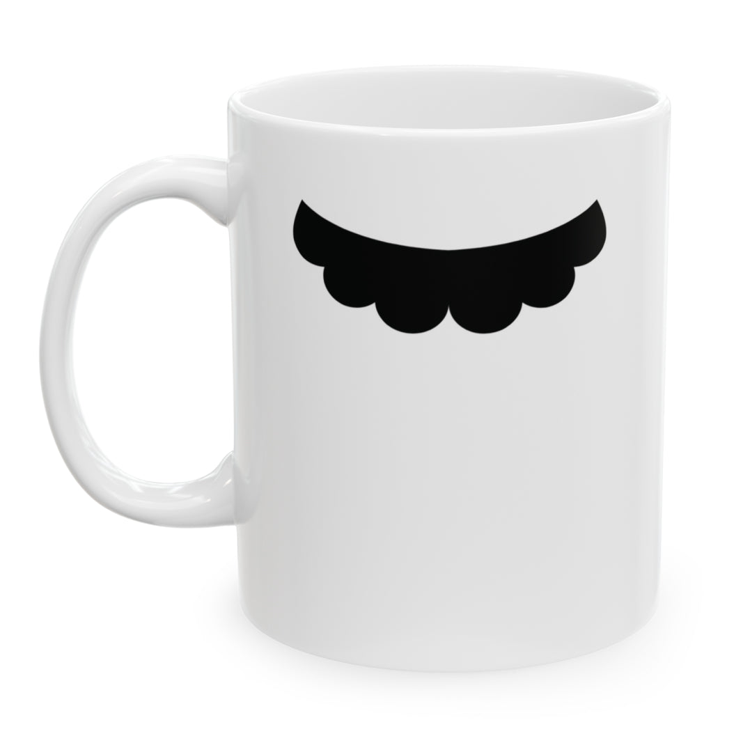 Photo of a white ceramic mug with a drawing of Mario Bros’s mustache, set against a plain white background.