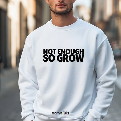 A man wearing a white flat-lay Sweatshirt with black typography that reads Not Enough So Grow