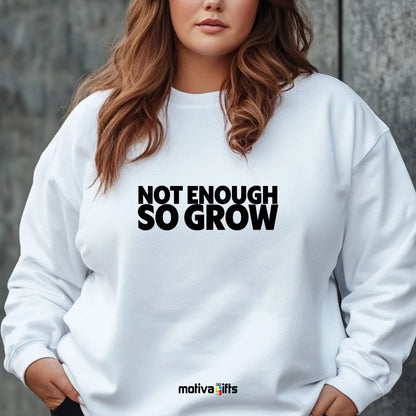 A woman wearing a white flat-lay Sweatshirt with black typography that reads Not Enough So Grow