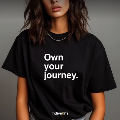 Woman wearing a black T-shirt featuring bold white typography that reads Own your journey 