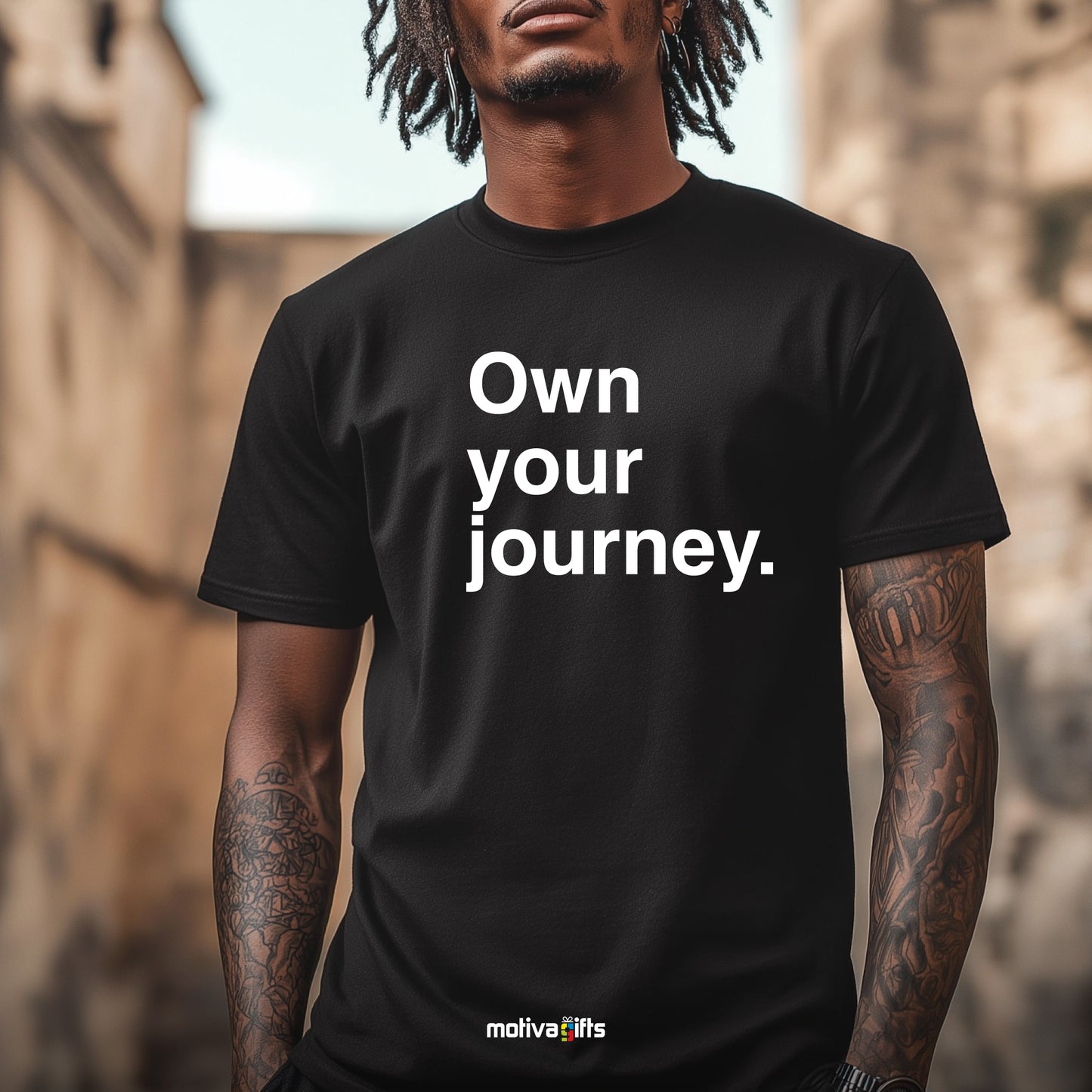 Man wearing a black T-shirt featuring bold white typography that reads Own your journey  