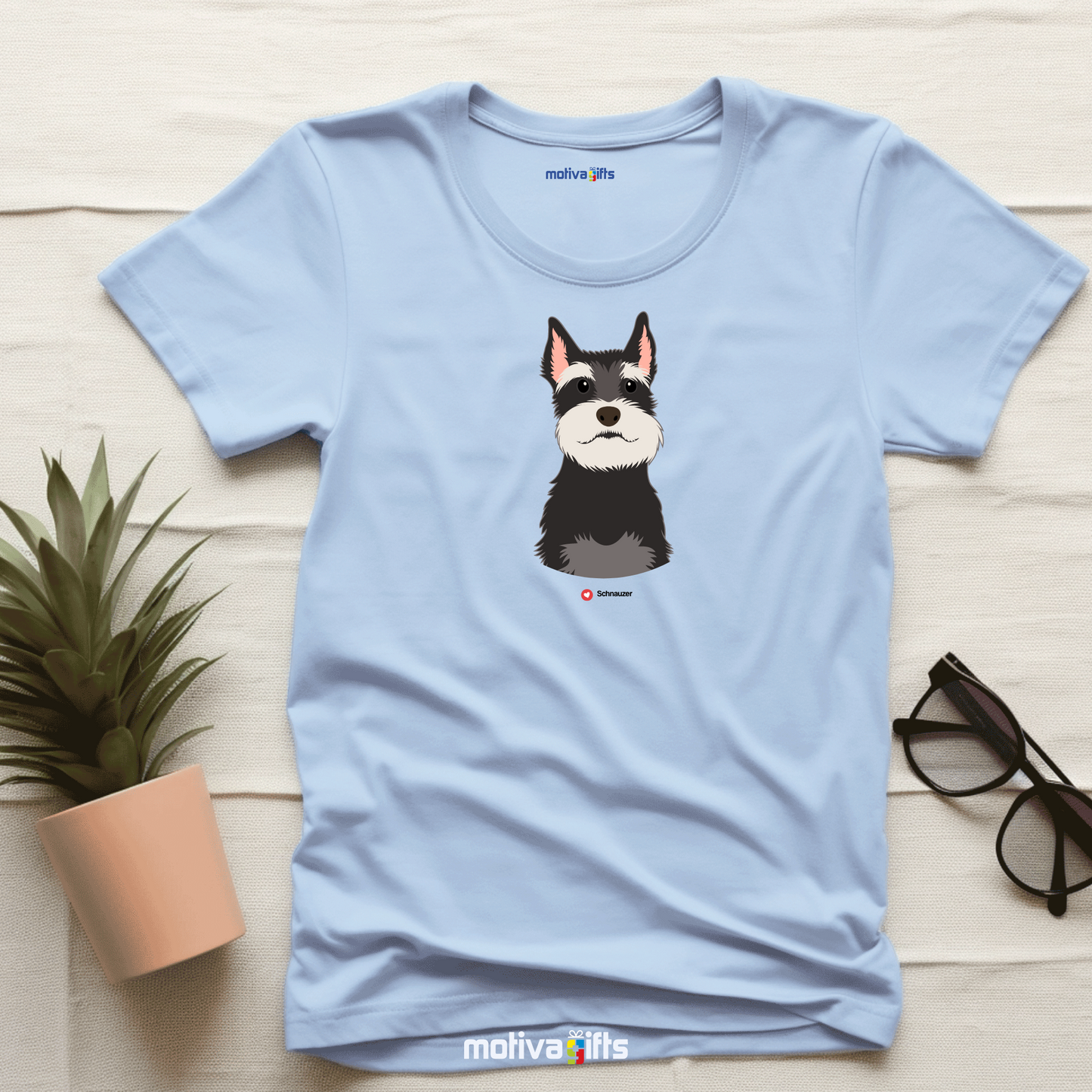 Flatlay, light blue tshirt with Schnauzer design on the front, front view, by Motiva Gifts.