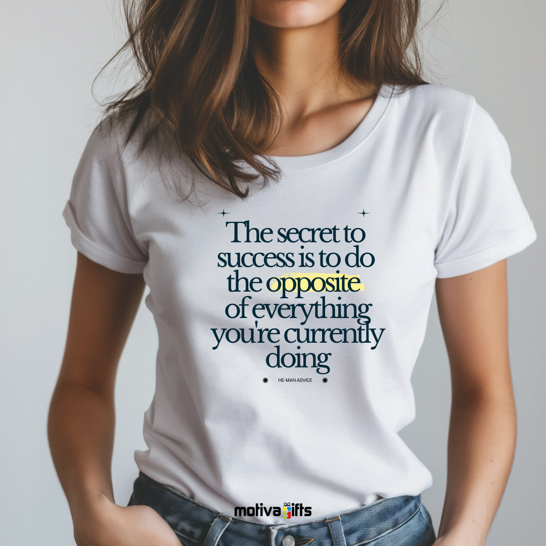 A woman wearing a white T-shirt featuring black typography that reads The secret to success is to do the opposite of everything you’re currently doing