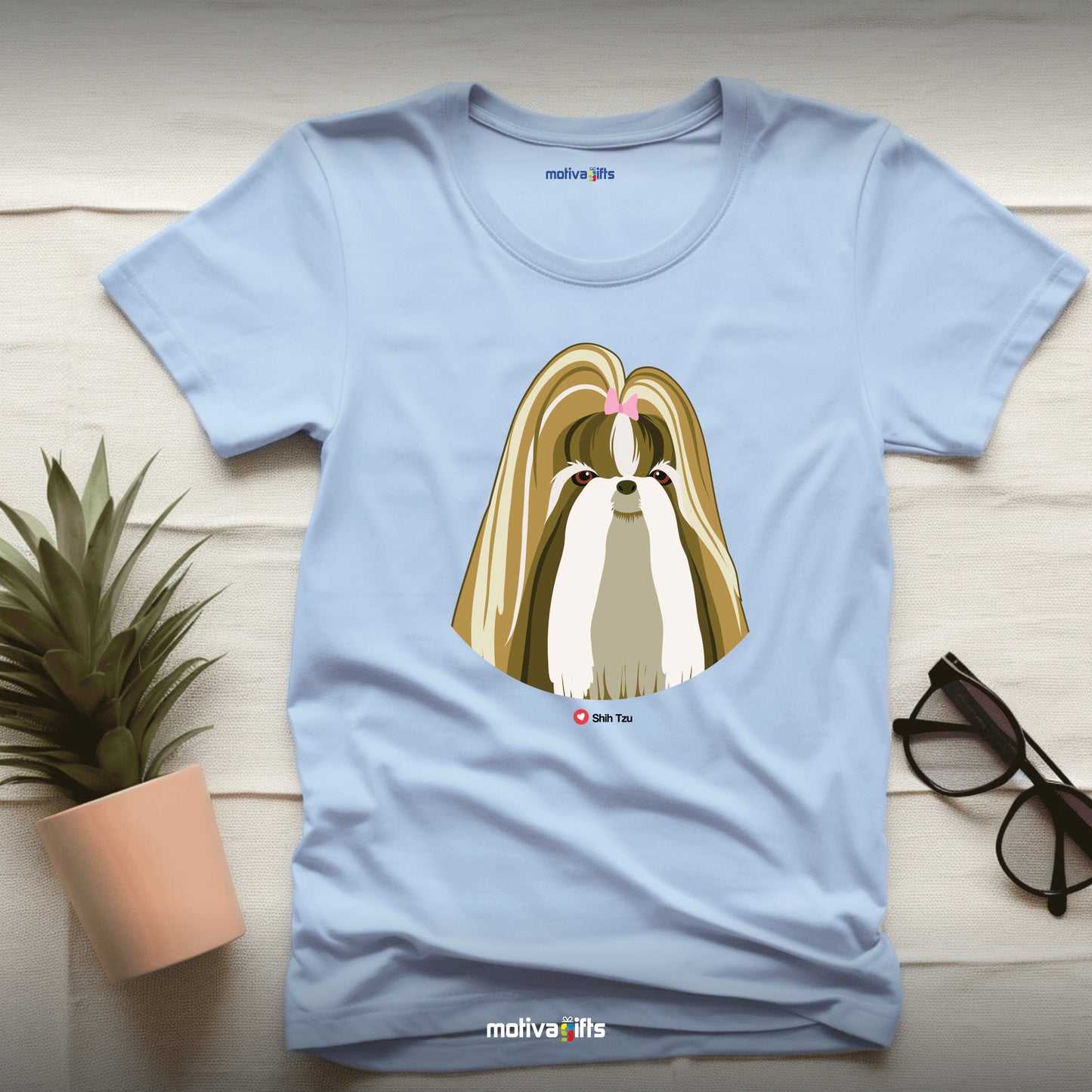 Flatlay, light blue tshirt with Shih Tzu design on the front, front view, by Motiva Gifts.