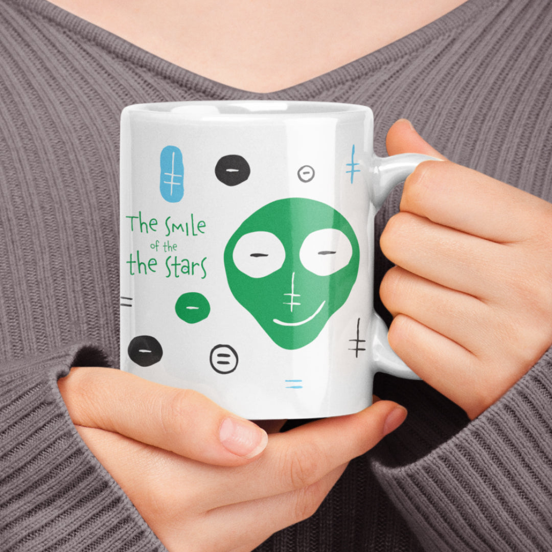 Woman holding a white ceramic mug with a drawing of Smile Of The Stars Mug