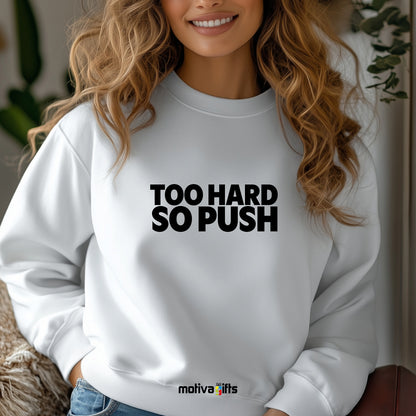 A woman wearing a white flat-lay Sweatshirt with black typography that reads Too Hard So Push