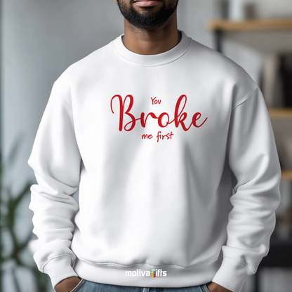 A man wearing a white crewneck sweatshirt featuring red typography that reads You Broke Me First