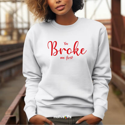 A woman wearing a white crewneck sweatshirt featuring red typography that reads You Broke Me First