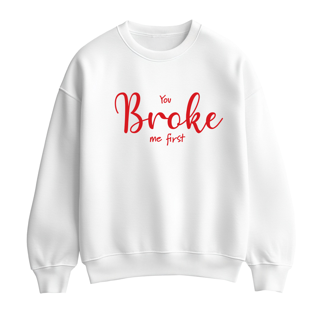 White flat-lay Unisex Crewneck Sweatshirt featuring red typography that reads You Broke Me First 